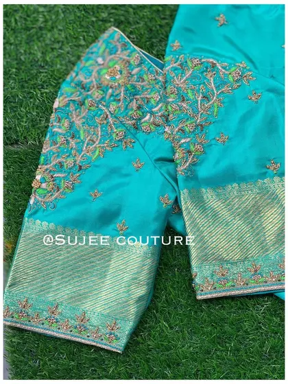 A full view of the teal blouse, showing the embroidered body and the contrasting brocade sleeves. This piece showcases a wonderful blend of color and texture.