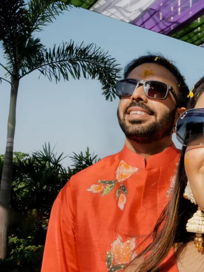 A cool and casual selfie-style shot of the couple during their outdoor haldi, capturing their relaxed and happy vibe.