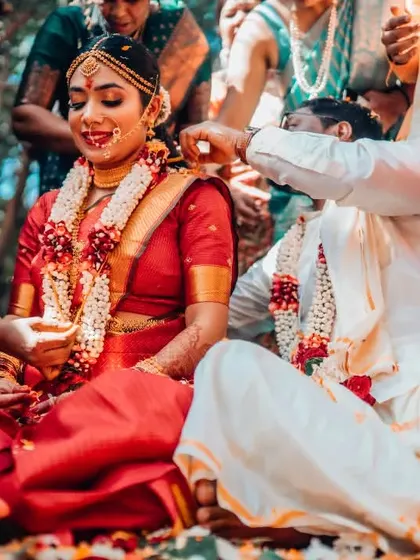 A joyful moment during a South Indian wedding ritual, with family members participating in the ceremony.