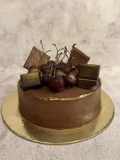 Our Belgian chocolate and cherry cake before its final decorations. The rich chocolate ganache is the perfect base for sweet, fresh cherries.