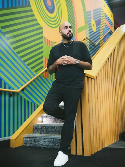Standing on a colorful staircase. My work is vibrant, creative, and always moving upward, just like the art behind me.