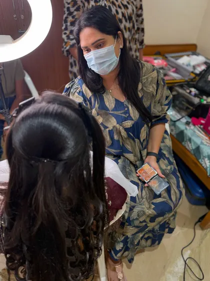 A behind-the-scenes shot of me working on a bride, Suvarna. This is the real-world application of the skills we teach.
