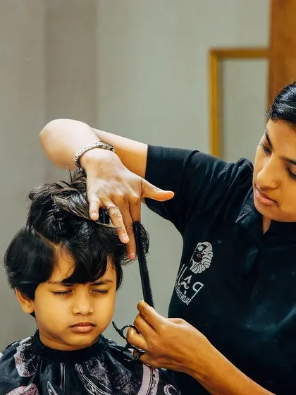 Our stylist is carefully giving this young boy a haircut. We are gentle and patient with all our little clients.