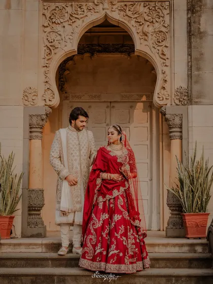 A romantic portrait of the couple in front of the palace doors.