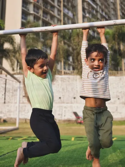 Two young brothers hanging out on the bars. We make fitness a fun activity that the whole family can get behind.