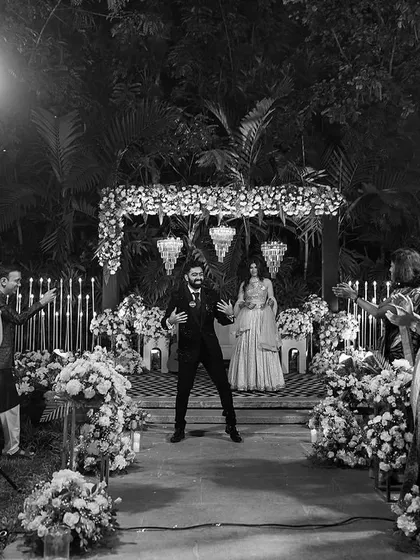 A black and white shot of the groom's energetic dance performance on the aisle, capturing the excitement of the moment.
