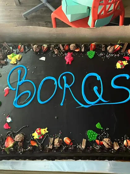 A massive, fully loaded chocolate cake for a corporate team celebration. We can customize the message and toppings to match your company's event.