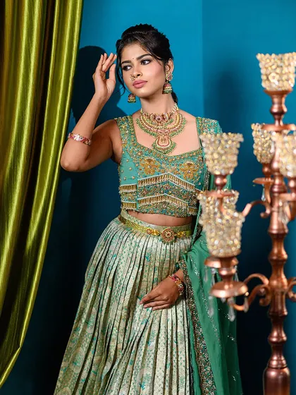 A full-length shot of a semi-traditional lehenga. The combination of a pleated skirt and an intricately embroidered top is perfect for an engagement or sangeet.