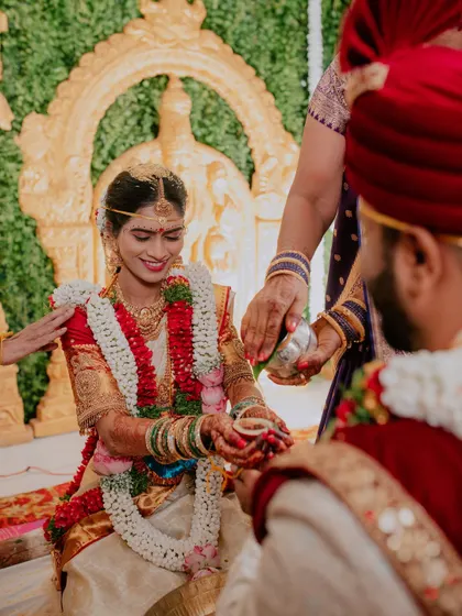 The bride participates in a traditional ritual during her wedding ceremony.