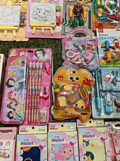 Here is a top-down view of my Kanjak return gift collection. You can see the variety I offer, from Disney Princess stationery sets and wallets to fun, food-themed erasers and small toys.