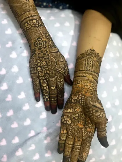 A lovely bridal design that combines floral elements with traditional architecture-inspired patterns on the forearm.