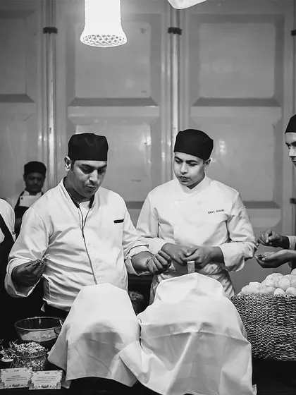 A black and white photo of our chefs in a huddle, getting briefed before service begins.