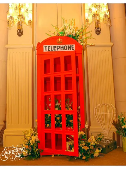 A life-sized red telephone booth prop, filled with flowers, served as a unique and beautiful photo opportunity for guests at the London-themed party.