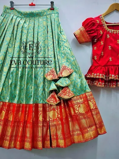 A beautiful lehenga set with a light green Banarasi skirt and a red peplum blouse. This is a perfect outfit for a wedding guest or for festive celebrations.