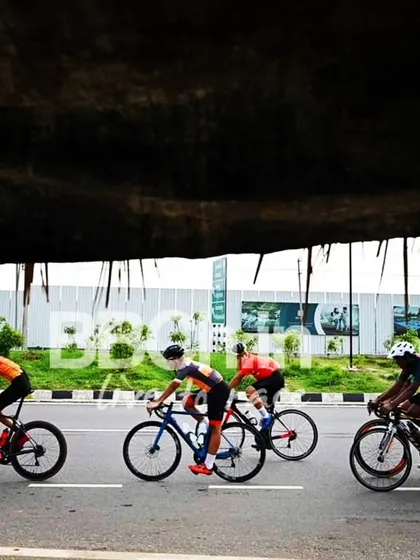 The elite peloton, framed by the darkness of an underpass, creates a dramatic shot.