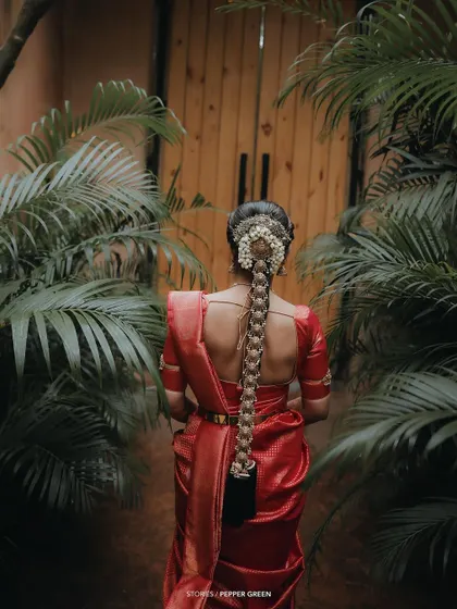 A beautiful shot of the back of the bride, showcasing her elaborate traditional hairstyle with a long braid and flowers.