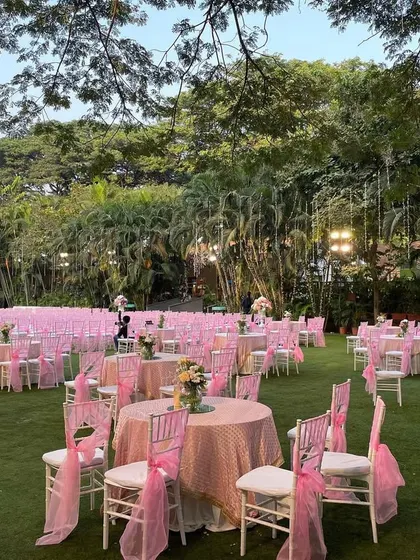 The guest dining area, with tables and chairs all themed in shades of pink, creating a cohesive and beautifully styled open-air setting.