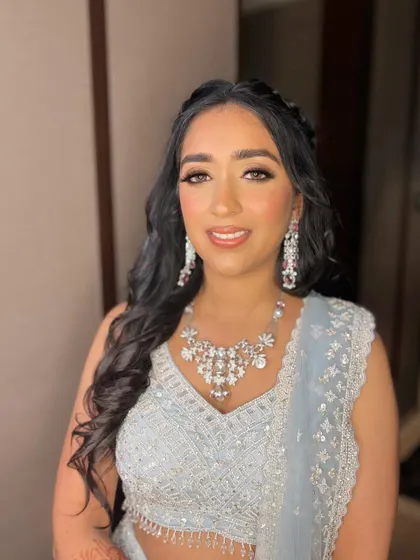 A classic smudged and smokey look for Sanskriti's engagement. This timeless style perfectly complements her shimmering light blue lehenga.