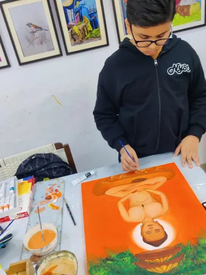 A student adds finishing touches to his painting, showcasing the focused environment of our studio where artists of all ages can learn and create.