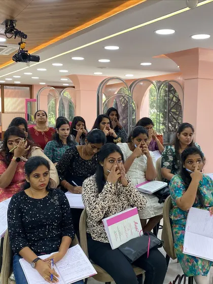 Students practicing nose contouring visualization on themselves before trying it on a model. This helps them understand the anatomy and placement.