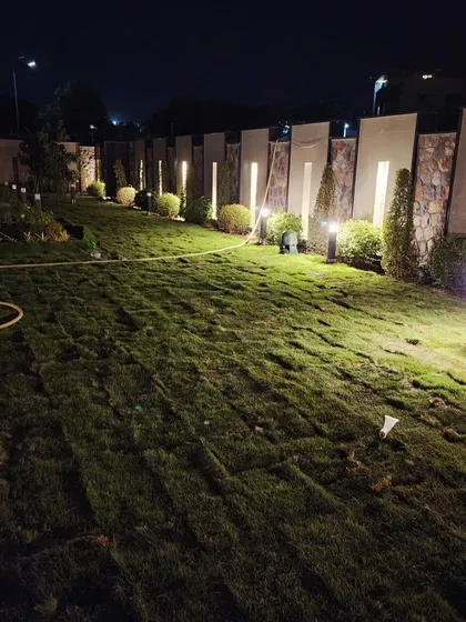 Nighttime is when a great landscape truly shines. Here, strategically placed uplighting and bollard lights illuminate the lawn and boundary wall, creating a safe and magical atmosphere.