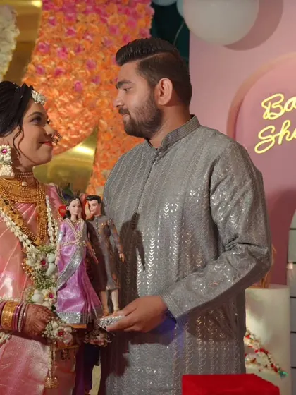 A candid moment between the couple as they hold their miniature lookalike dolls. These custom pieces are always a conversation starter at any event.