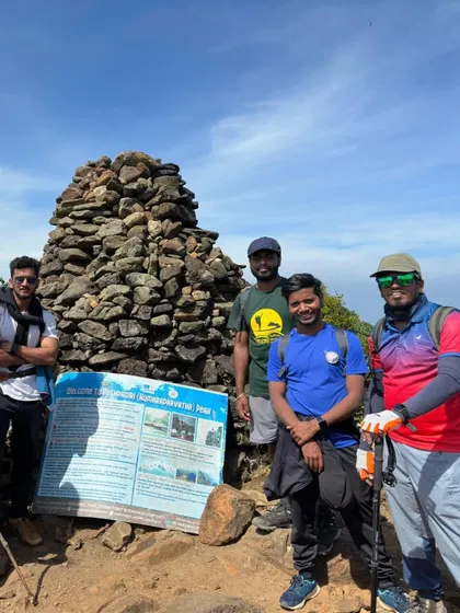 Another proud group at the Pushpagiri peak sign. Using trekking poles, as seen here, is highly recommended for this difficult climb.