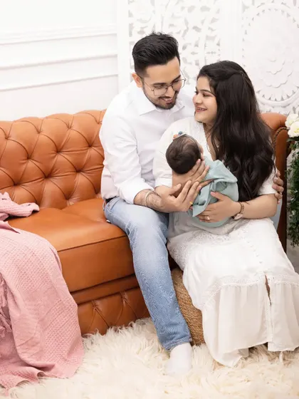 This candid shot from a newborn lifestyle session shows the joy and wonder of new parenthood. We use soft lighting and comfortable props like this shag rug to create a warm and inviting atmosphere.