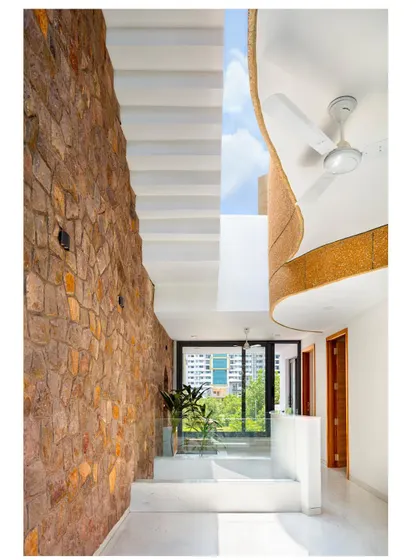 A large, curved skylight floods this double-height volume with natural light, while also directing rainwater into a storage tank, showcasing the fusion of aesthetic form and sustainable function.