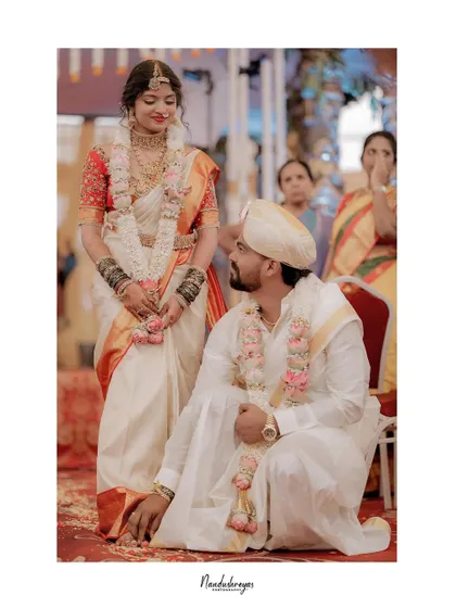 A poignant moment from a traditional wedding ceremony, showing the couple's reverence and connection. The composition highlights the solemnity of the ritual.