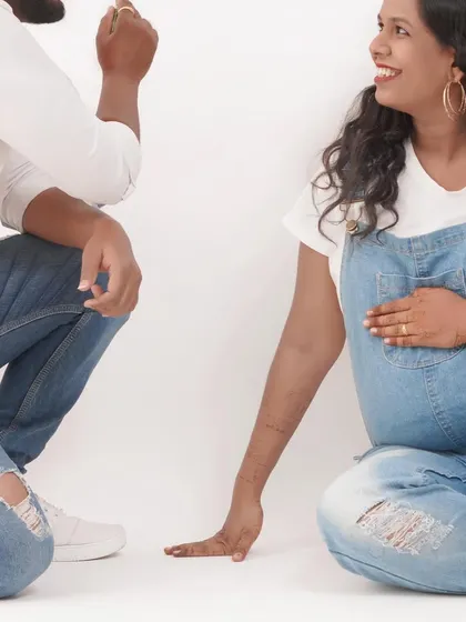 A close-up, candid moment between an expecting couple during their casual denim-themed photoshoot. These are the real, happy moments I love to capture.