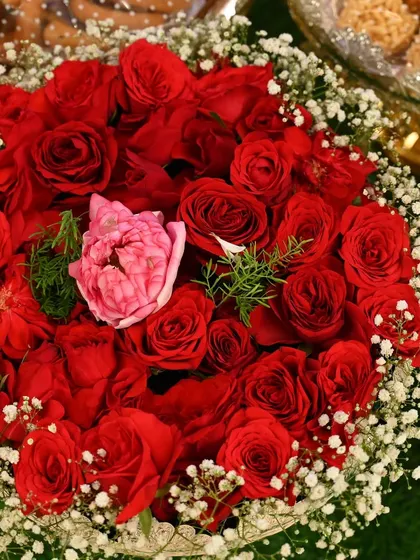 A stunning floral arrangement of red roses and baby's breath, perfect for adding a touch of elegance to any decor setup.