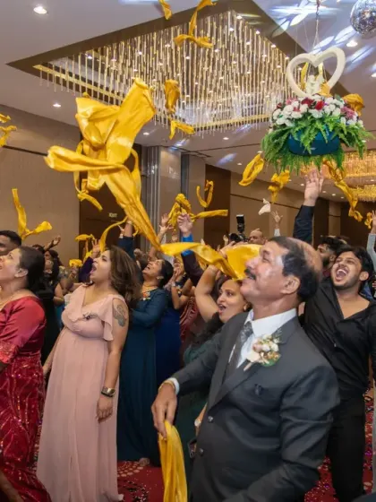 The bouquet and garter toss is always a moment of fun and anticipation. Here, guests reach for the flying streamers, creating a dynamic and colorful action shot during the reception.