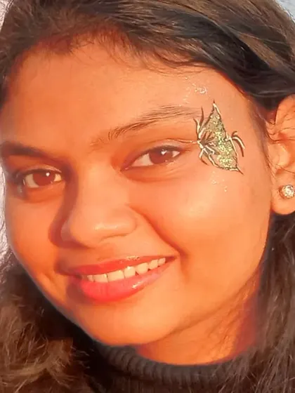 A close-up of a green and gold glitter butterfly, sparkling in the sun.