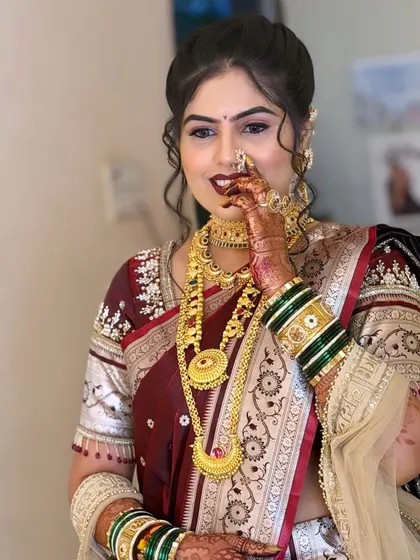 A happy bride showing off her complete look. The Maharashtrian nath and the intricate details of her jewellery are the highlights here.