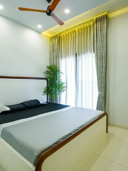 Soft tones and natural light define this bedroom’s minimalist aesthetic. The clean lines of the bed frame and simple decor create a sense of calm and openness.