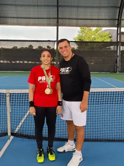 A duplicate image of our national deaf-tennis champion with her coach, celebrating her victory.