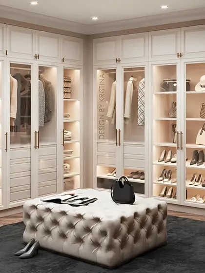 The ultimate dream closet. This stunning walk-in wardrobe features glass-fronted doors, custom-lit shelving for shoes and bags, and a large central ottoman. It’s the perfect blend of luxury and organization.
