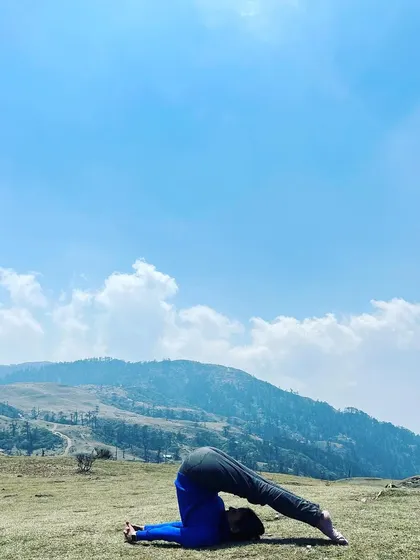 Moving into Halasana, or plough pose, after shoulder stand. This pose provides a deep stretch for the entire spine and the back of the legs, a much-needed release after a day of trekking.