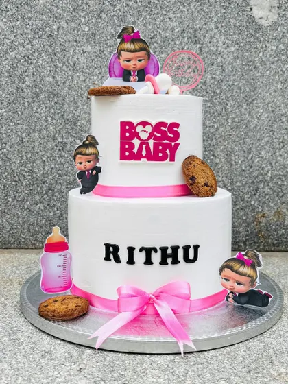 A two-tier Boss Baby cake for a little girl's party. I used pink ribbons, character toppers, and even some cookie details to match the theme perfectly.