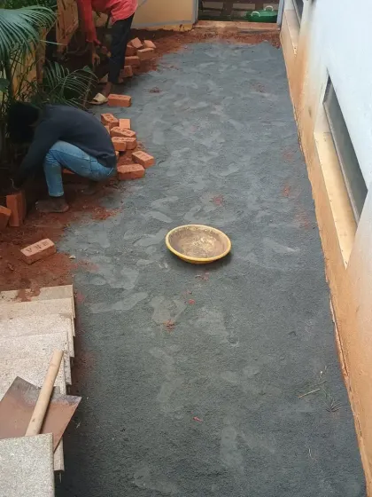 In this project, I am also installing a brick border along the edge of the prepared base before laying the turf.