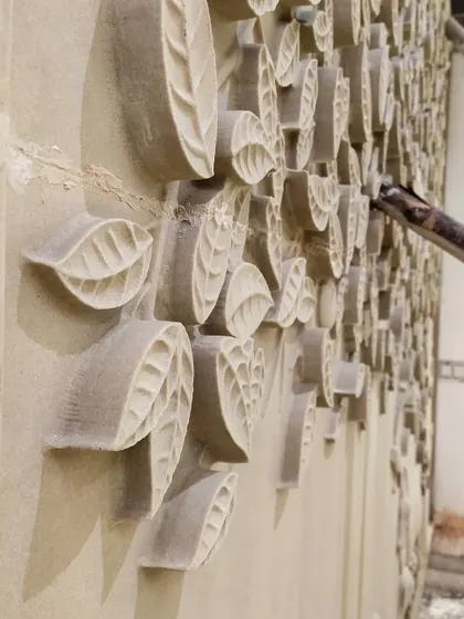 Here, our team is meticulously installing custom-carved sandstone panels on a double-height wall. This shows our focus on using natural materials and intricate craftsmanship to create unique, textured accent walls.