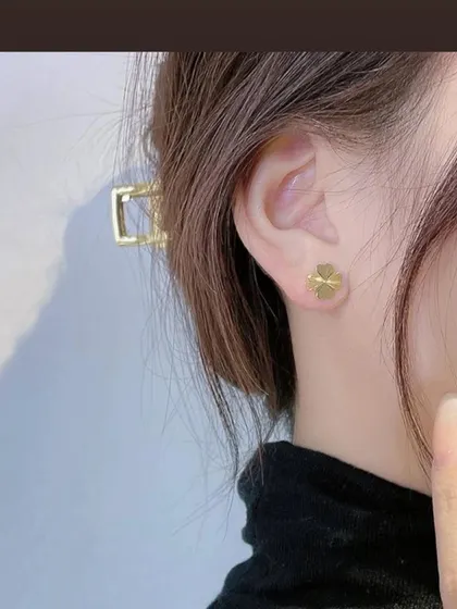 A model wearing the simple and classic four-leaf clover stud earrings. These are made from high-quality, color-stable stainless steel.