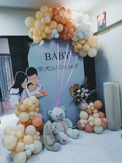 A personalized baby shower setup featuring a custom cutout of the family. This is a wonderful way to add a personal touch, complemented by teddy bears and a soft-colored balloon arrangement.