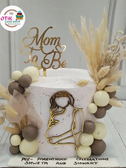 A closer look at our bohemian-themed "Mom to Be" cake. The combination of textures, from the rough-edged buttercream to the dried pampas grass, creates a beautiful, rustic look.