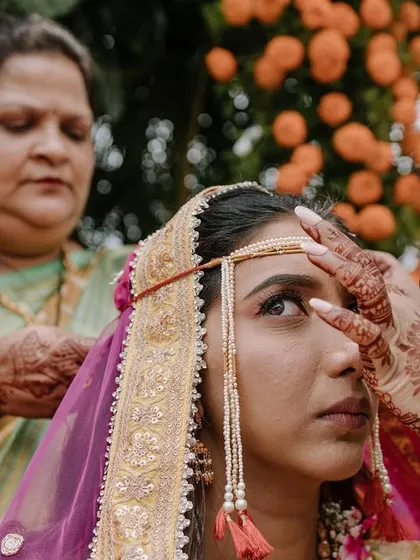 A touching moment during a Marathi wedding as the traditional 'Mundavalya' is tied to the bride's forehead by her family.