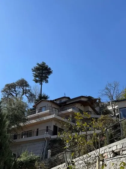 'Soulitude in the Himalayas,' a project nearing completion. The building is terraced into the hillside, with balconies and large windows designed to capture the stunning views of the surrounding mountains.