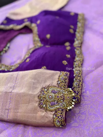 A purple blouse with a statement motif on the sleeve.