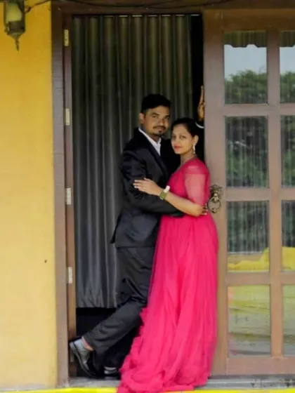 An intimate pose by a rustic doorway. Her flowing pink ruffle gown and his classic black suit create a beautiful contrast.