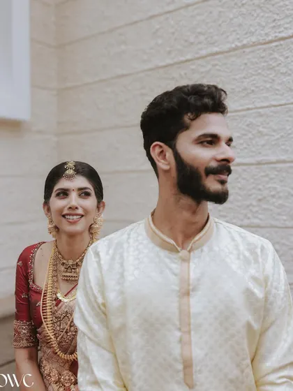 A candid shot of the bride and groom, her smiling face appearing from behind him, capturing a sweet, unposed moment.